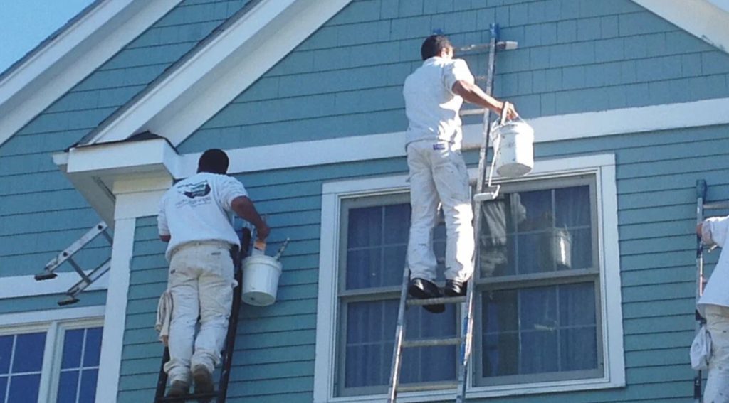 All Coast Painting crew painting exterior of a house in Miami, addressing humidity and weather challenges.