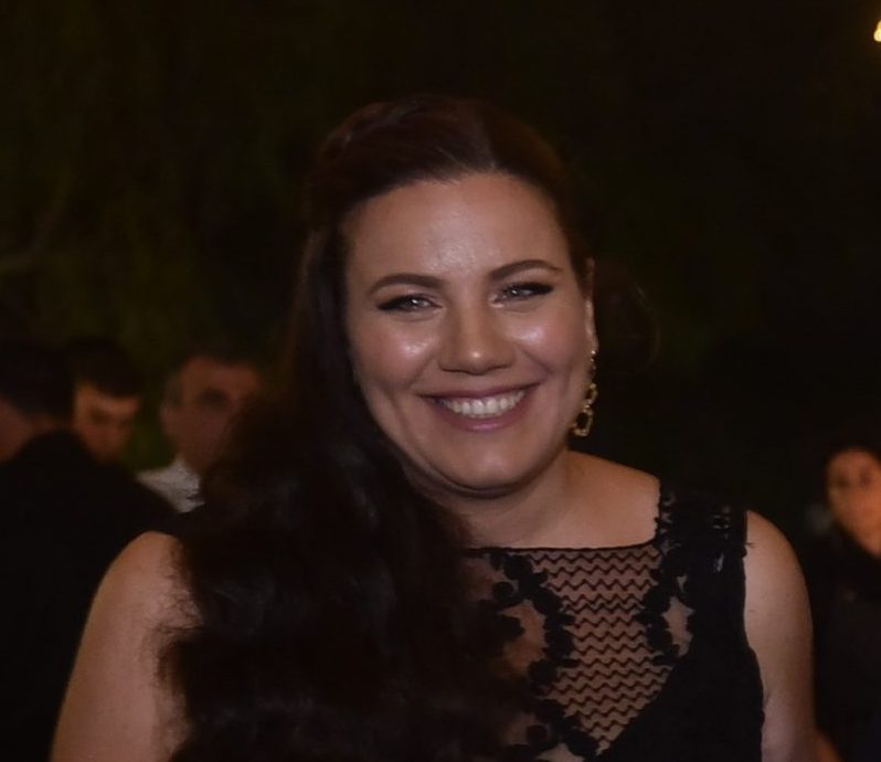 Sara Baruch, founder of All Coast Painting LLC, smiles confidently in a portrait showcasing
